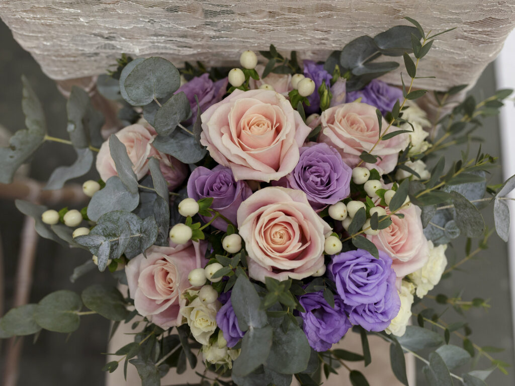 Wedding day flowers. top view of a Bridal bouquet consisting of pale pink, purple and ivory roses with eucalyptus