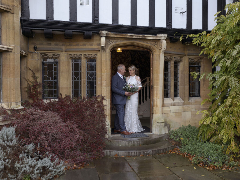 Bride and Groom stood in the doorway of The Petwood Hotel.