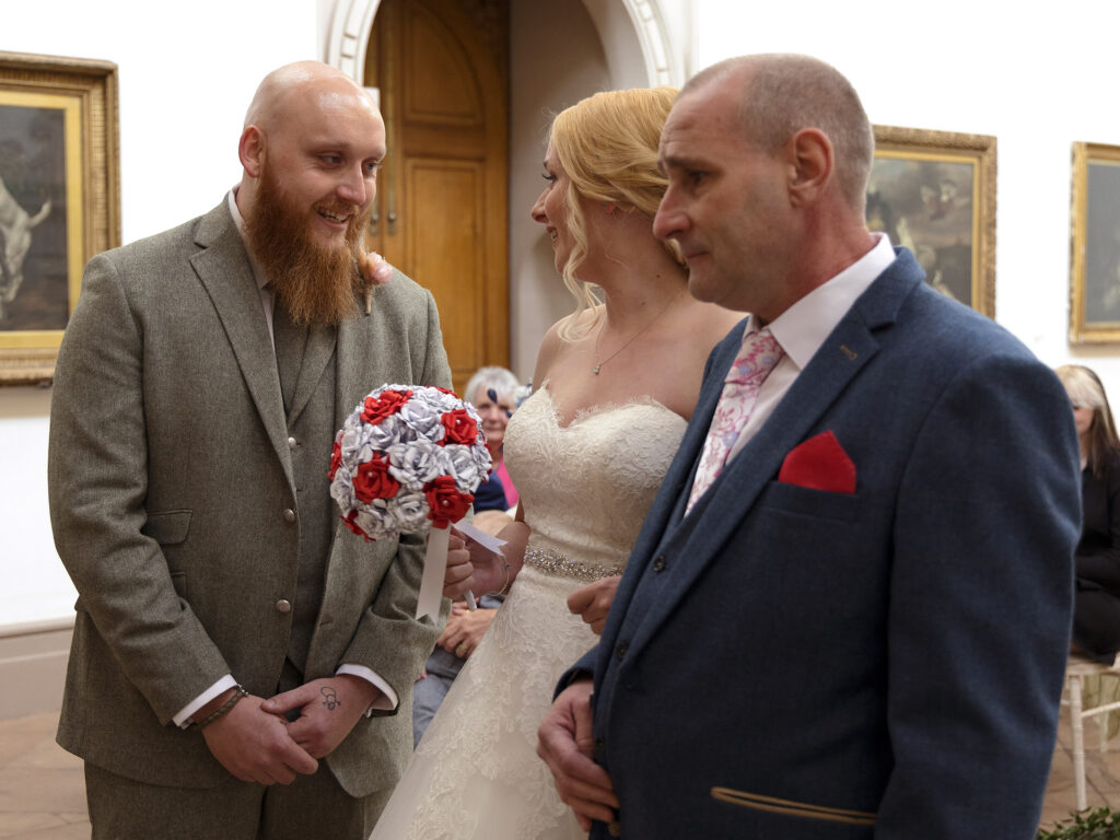 The Groom is seeing his Bride for the first time as she arrives at the top of the aisle with her dad at Wollaton Hall