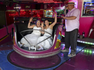 Nottingham riverside wedding blog shows brightly coloured haired brides in a waltzer at Nottingham riverside festival