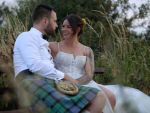 Grrom wearing a kilt is sat nect to his Bride taking in a quiet moment
